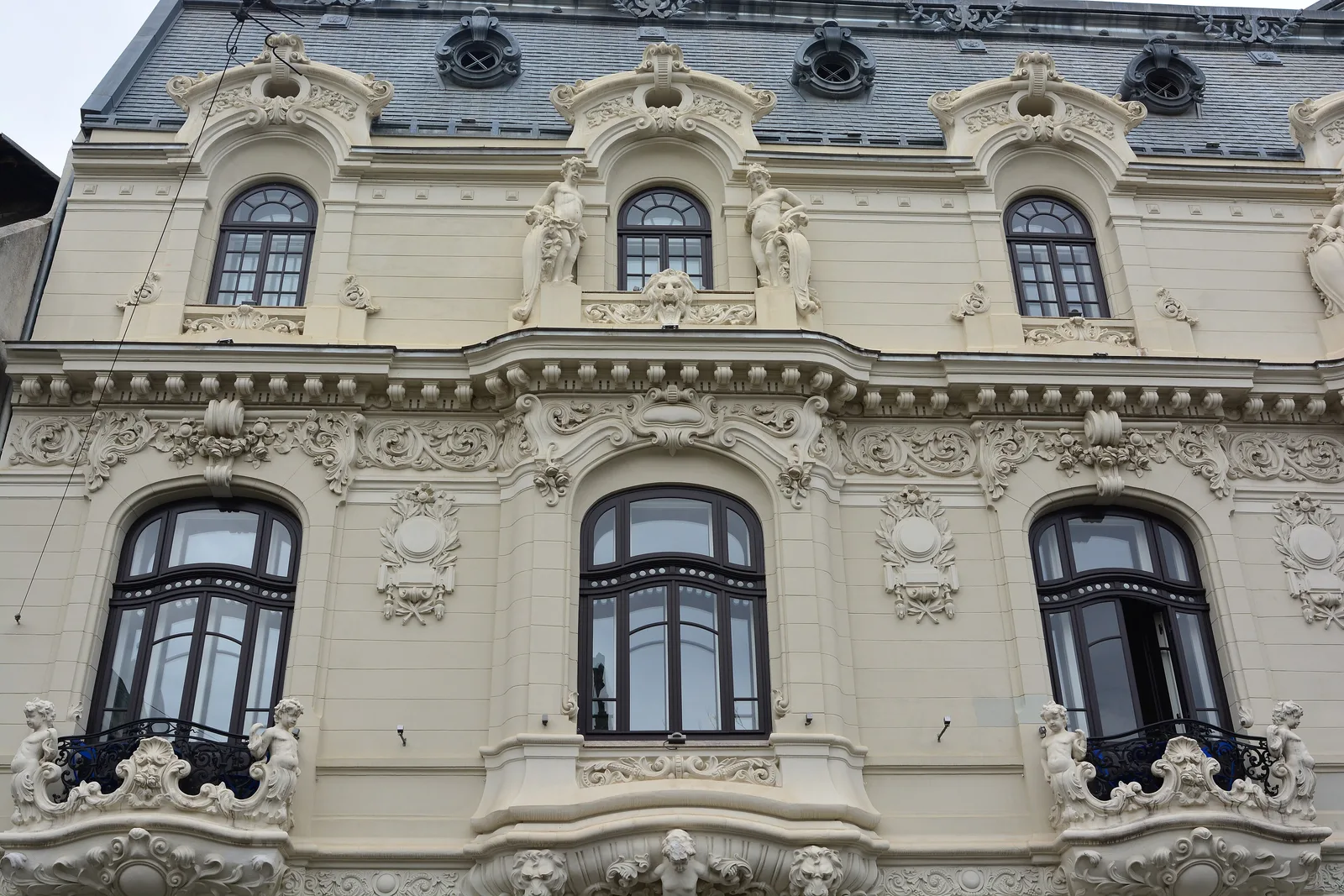 The richly decorated Art Nouveau facade of Casa Mița Biciclista near Piața Amzei, Bucharest, with carved cherubs and garlands around the arched windows