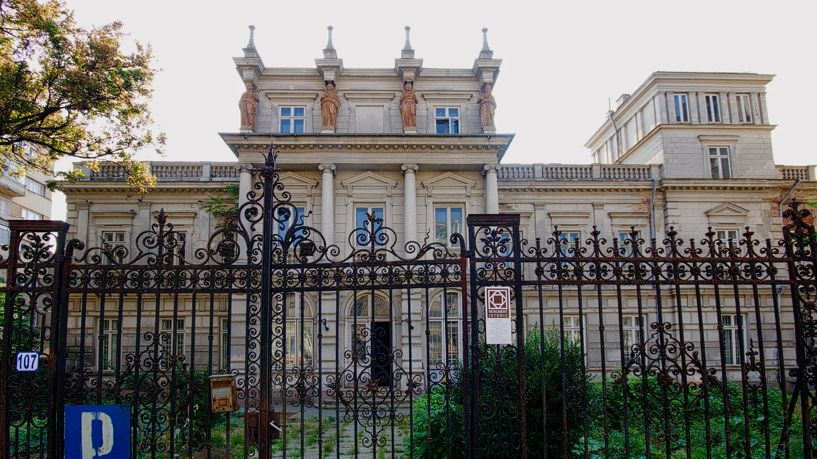 Știrbei Palace at Calea Victoriei 107 in Bucharest, with four caryatid statues along the top floor, seen through the iron gate in 2011, before its restoration