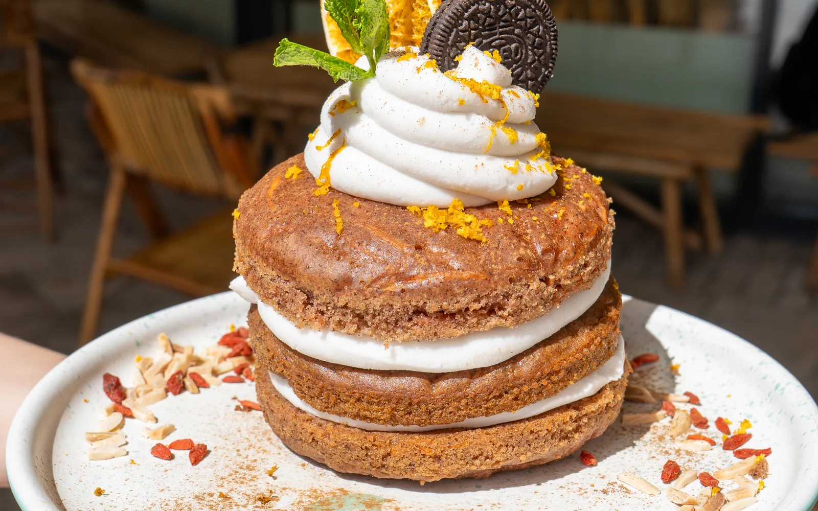 A carrot-cake pancake stack layered with cream and topped with dried orange, mint and an Oreo at Cookie Beacon