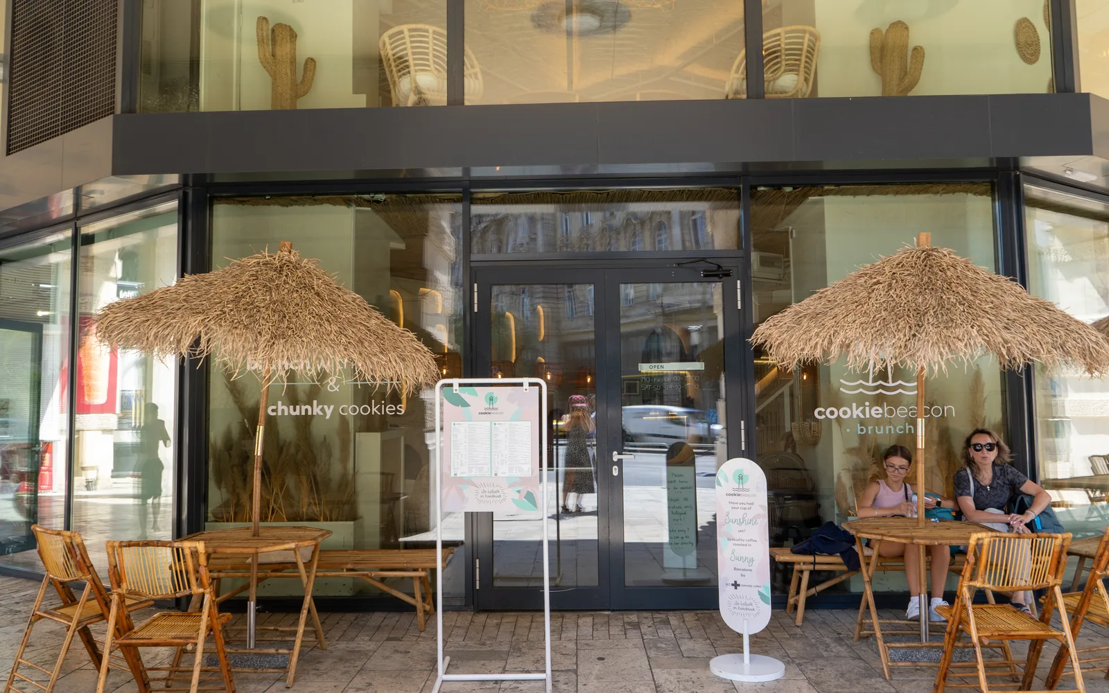 Szalmaernyős teraszasztalok a Cookie Beacon Ferenciek téri brunch-helye előtt, Budapesten