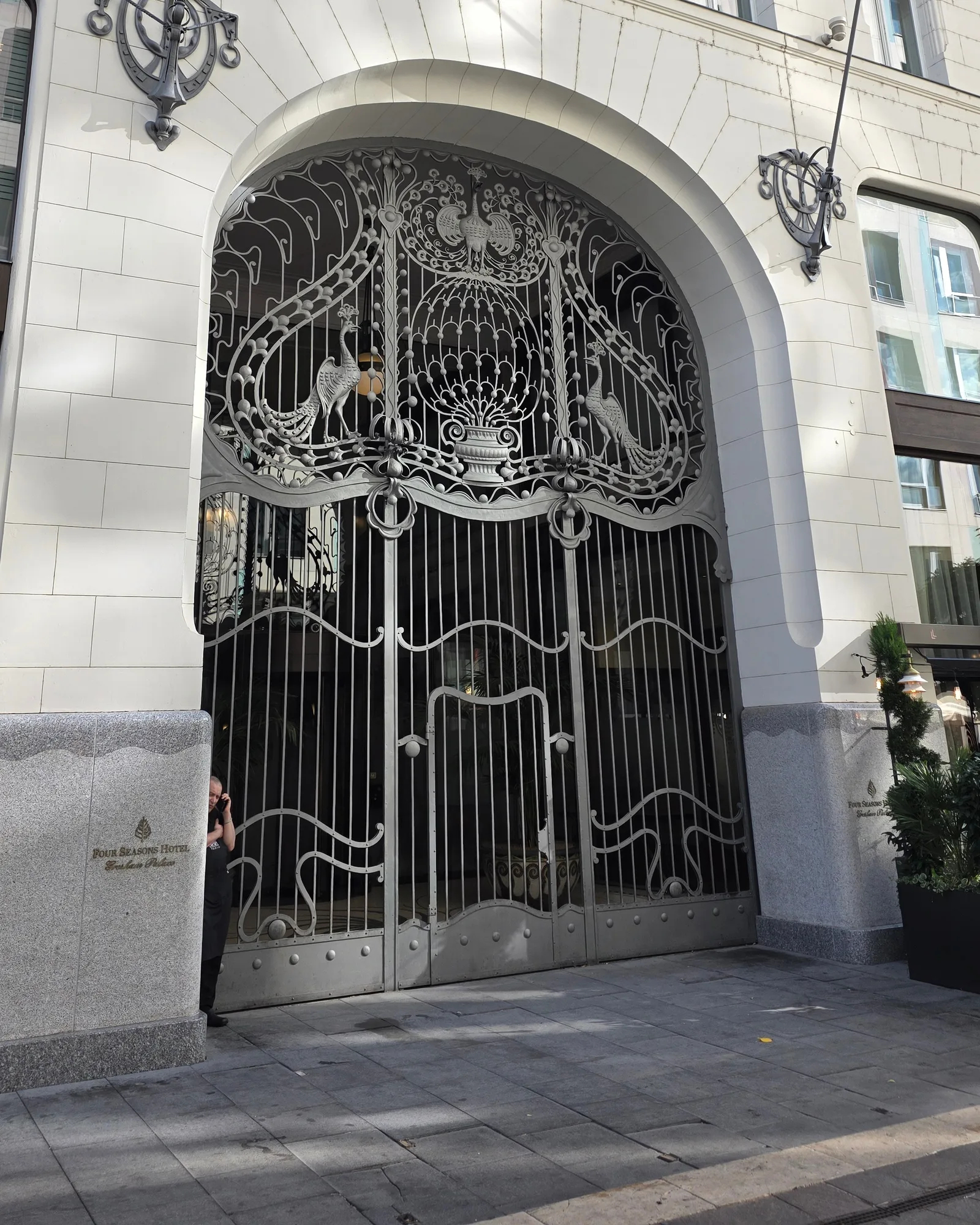 The arched wrought-iron gate of Gresham Palace in Budapest, with peacock shapes in the ironwork