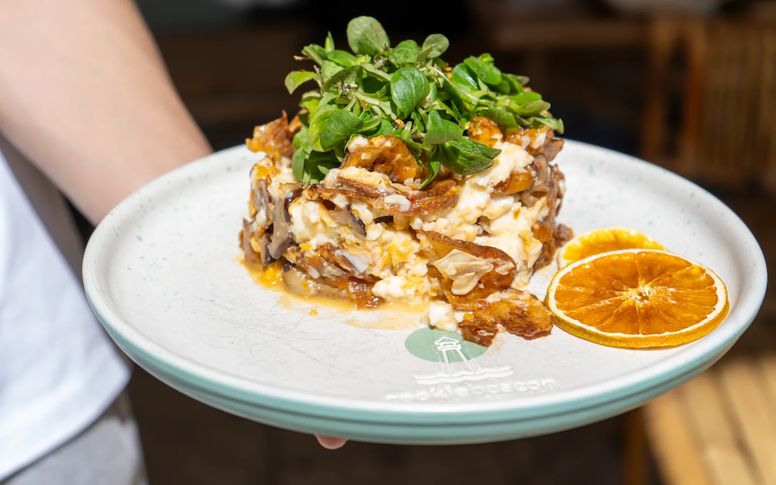Madrid Smashed Eggs ropogós burgonyával, lágy tükörtojással, shiitake gombával és madársalátával, felszolgálás közben a Cookie Beacon budapesti reggelizőjében