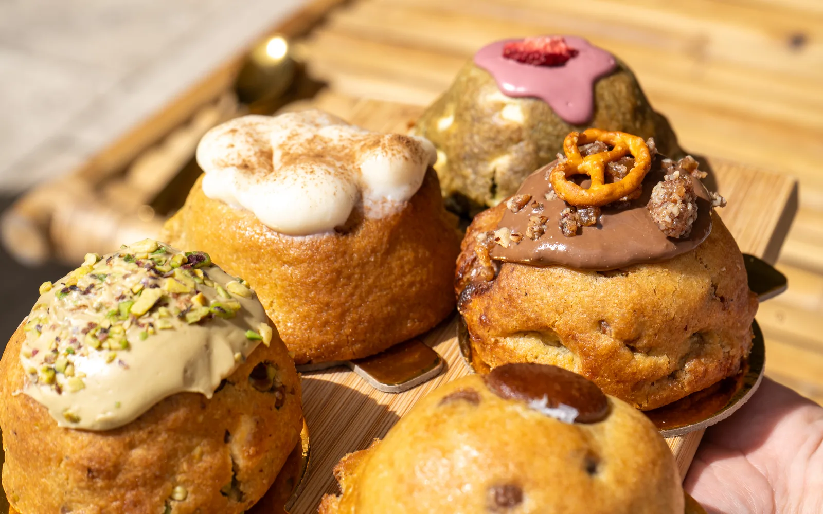 Chunky cookies on a wooden board at Cookie Beacon Budapest, topped with pistachio, chocolate and marshmallow