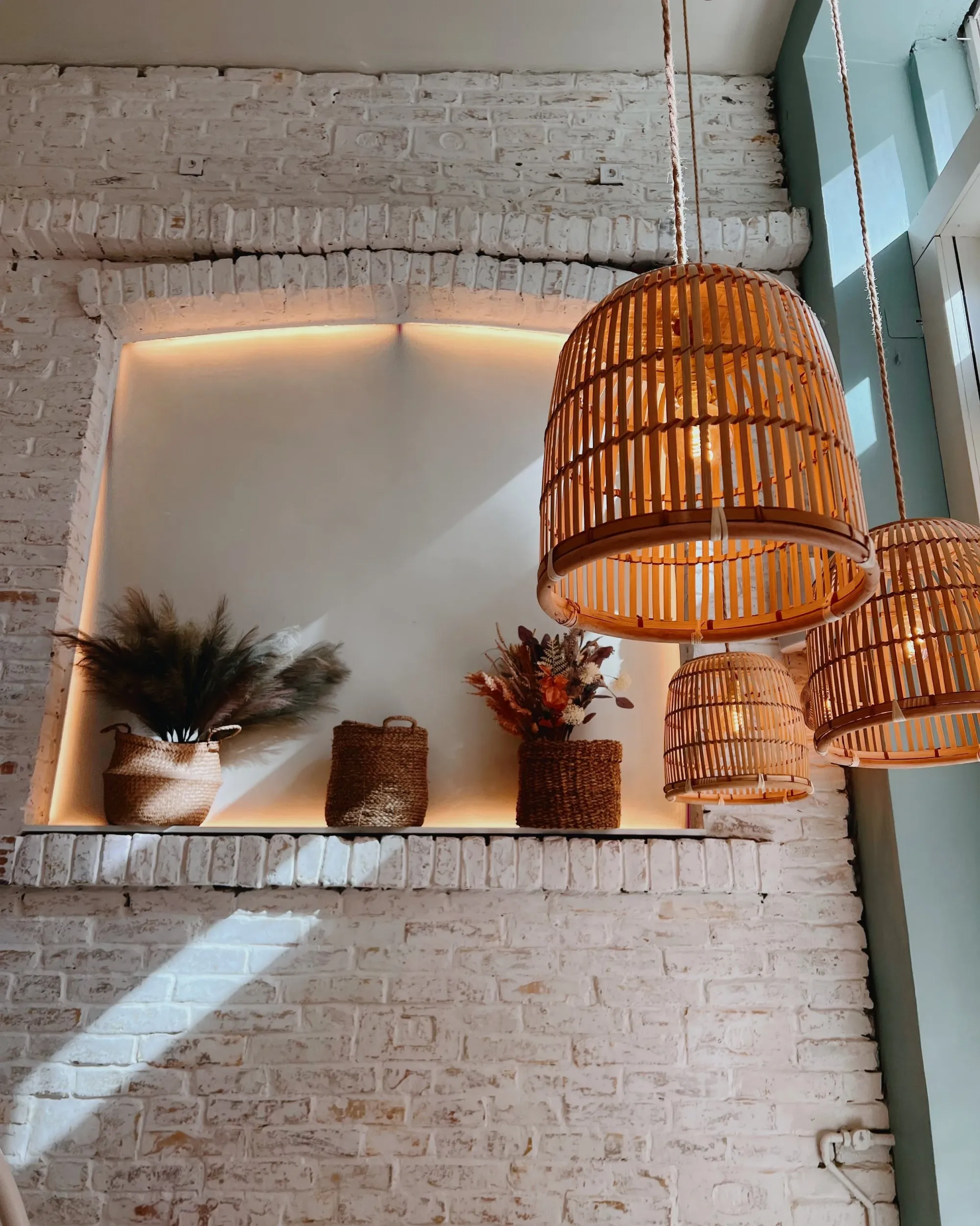 Inside a Cookie Beacon brunch spot — whitewashed brick, woven pendant lights and dried flowers
