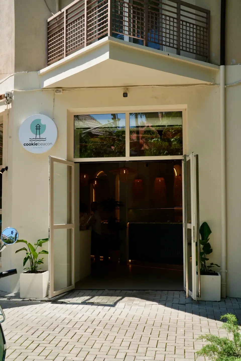 The open glass doors and the round cookiebeacon brunch sign at the entrance to Cookie Beacon Floreasca on Calea Floreasca in northern Bucharest