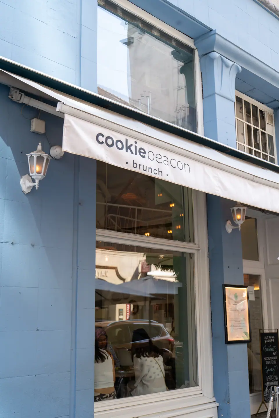 The cookiebeacon brunch awning and lantern on the blue façade of the Budapest café near St. Stephen's Basilica