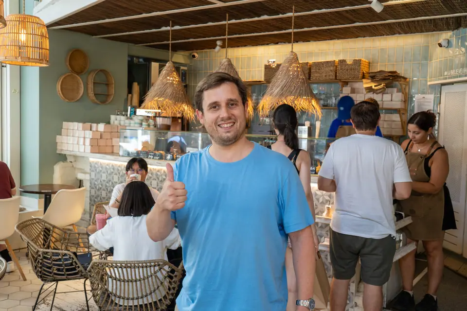 Someone giving a thumbs up in the ground-floor room at Cookie Beacon Budapest, under the rattan lamps