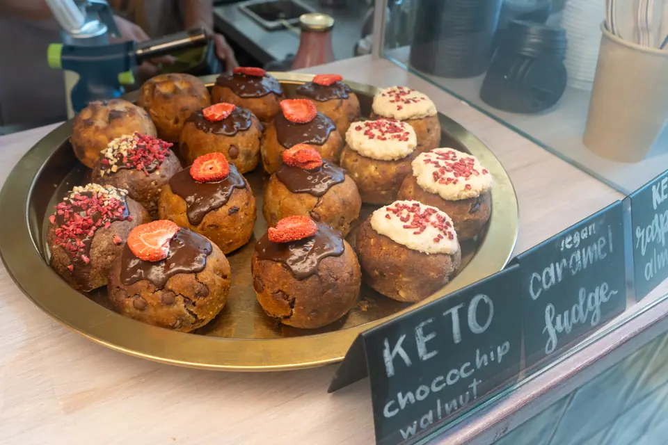 A brass tray of keto chocolate-chip walnut cookies topped with strawberries at Cookie Beacon Ferenciek tere
