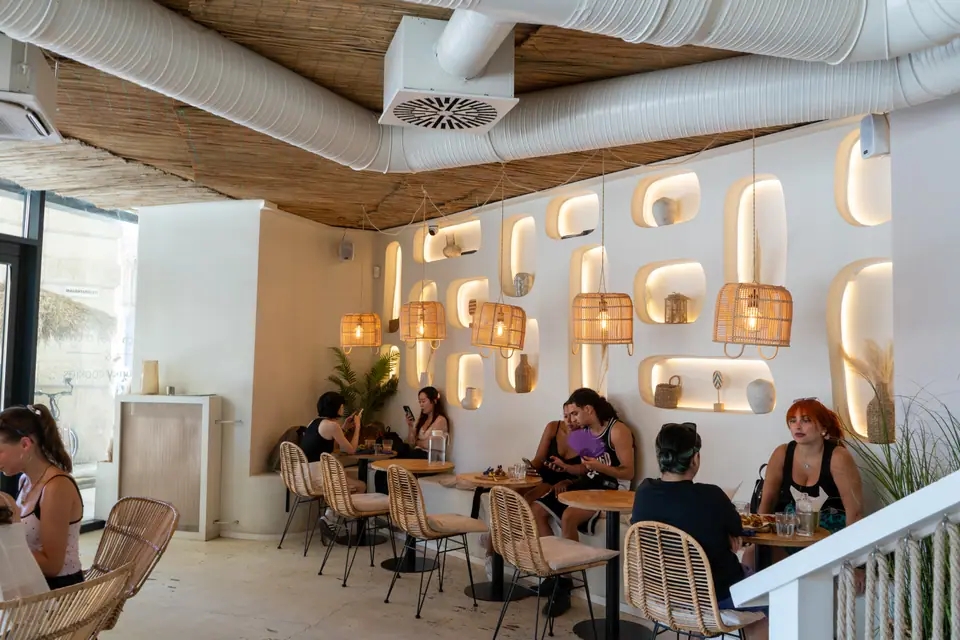 Guests at tables along the sculpted wall of lit alcoves upstairs at Cookie Beacon Ferenciek tere, Budapest