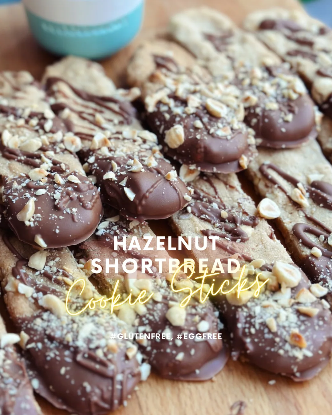 Chocolate-dipped hazelnut shortbread cookie sticks topped with crushed toasted hazelnuts