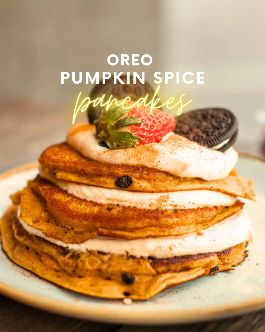 Stack of pumpkin pancakes layered with cream cheese sauce, topped with cinnamon, strawberry and Oreo
